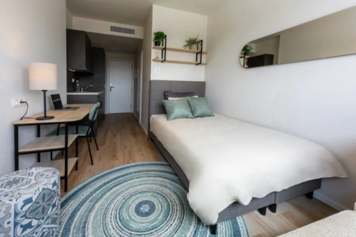 Signature studio interior with bed, kitchenette and desk