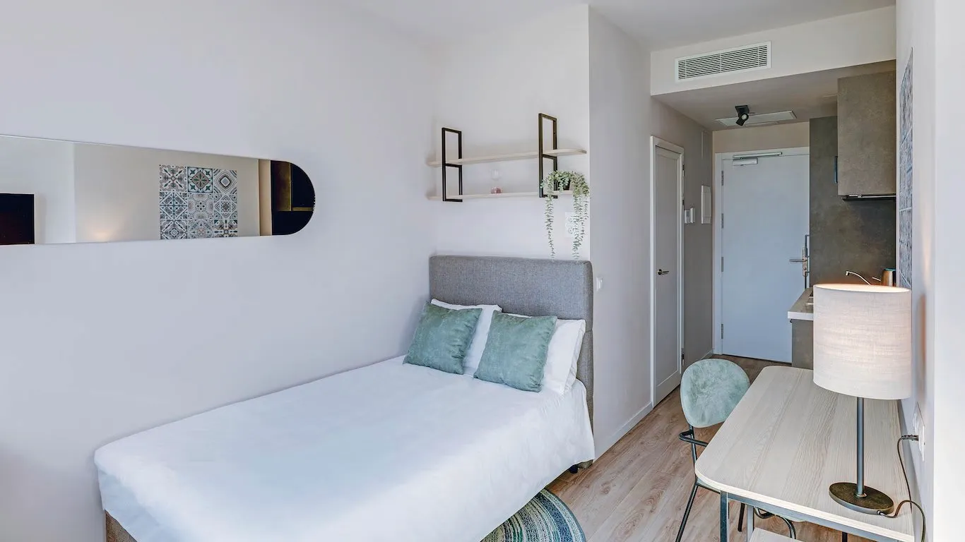 Prestige studio interior with double bed, workspace and rug