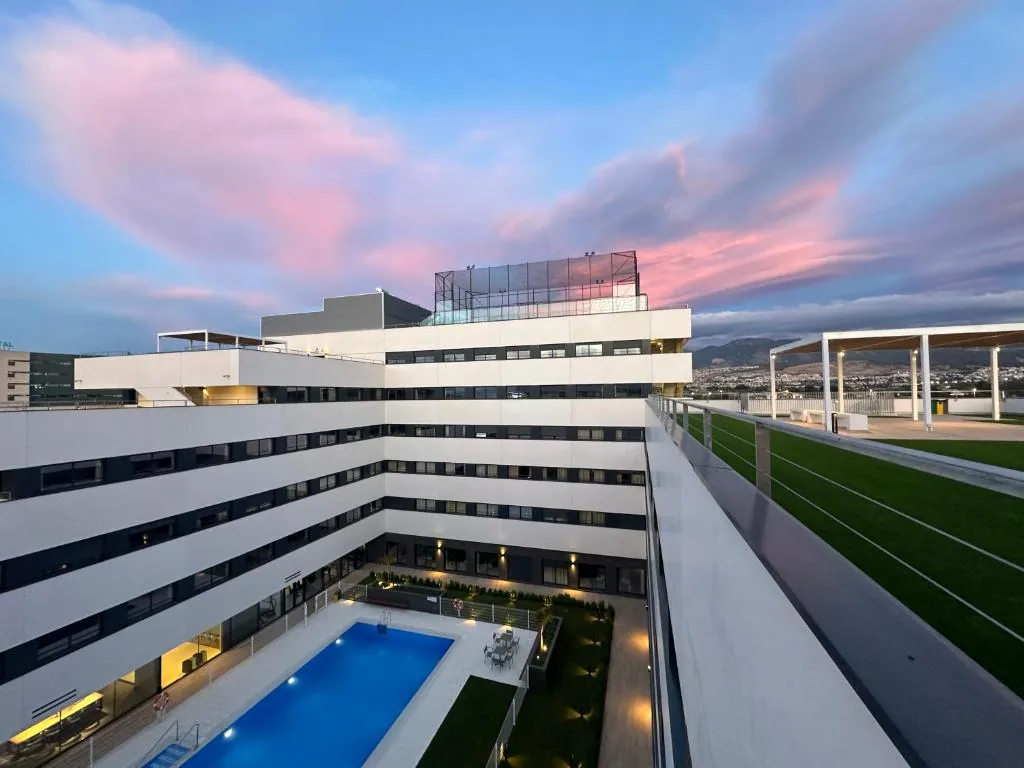 Living Experience Granada building with outdoor pool at sunset